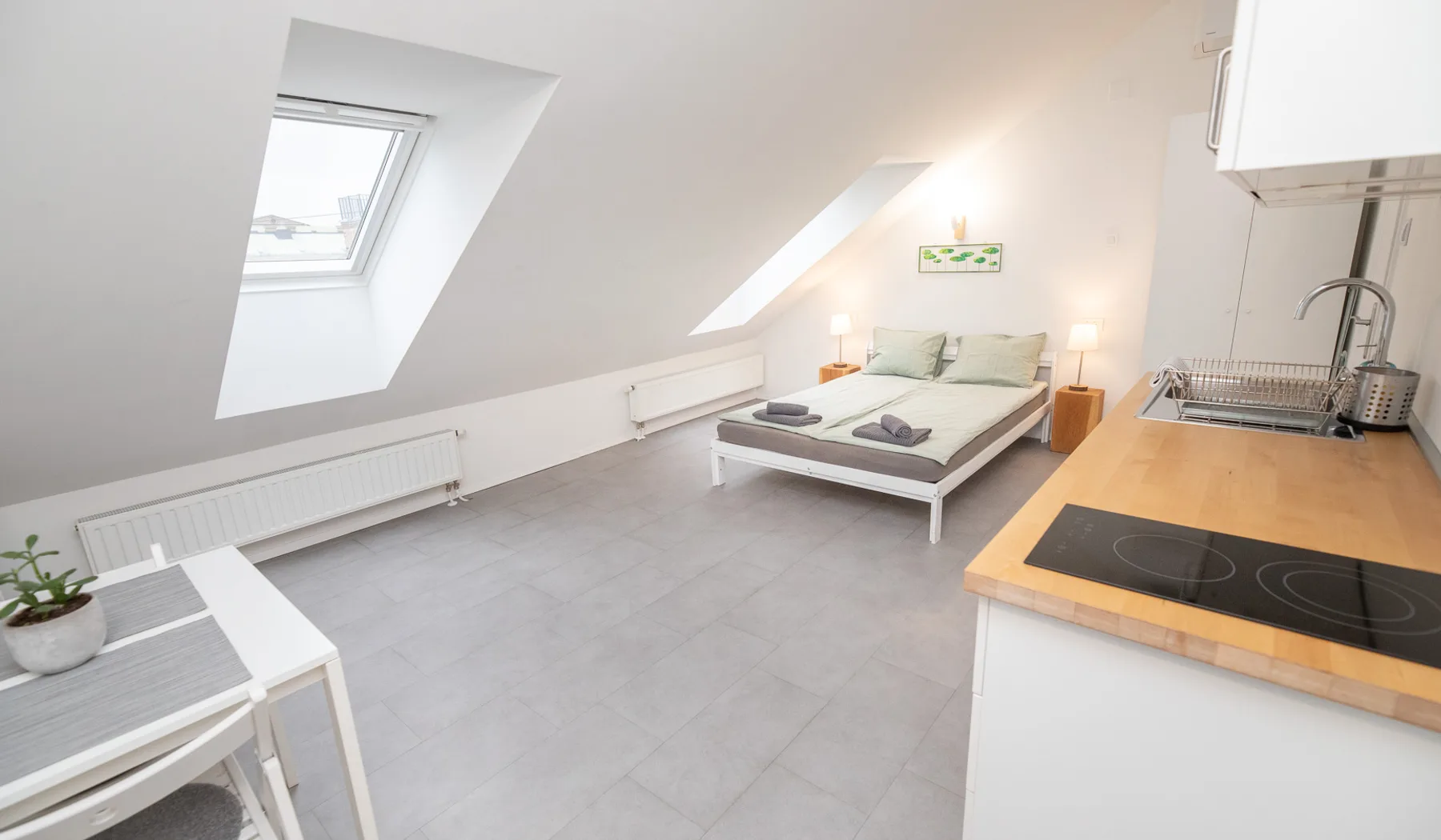 Woody 1 attic studio apartment in Zagreb with a skylight, double bed, kitchenette and dining table