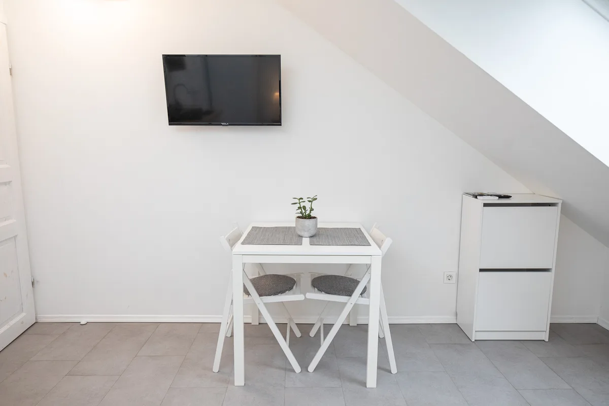 Dining table for two and wall-mounted television under the sloping ceiling in Woody 1, Zagreb