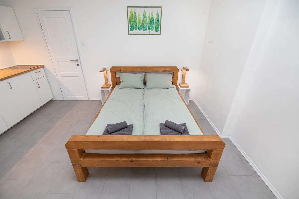 Solid pine double bed with wooden block reading lamps in Woody 2 studio apartment, Zagreb