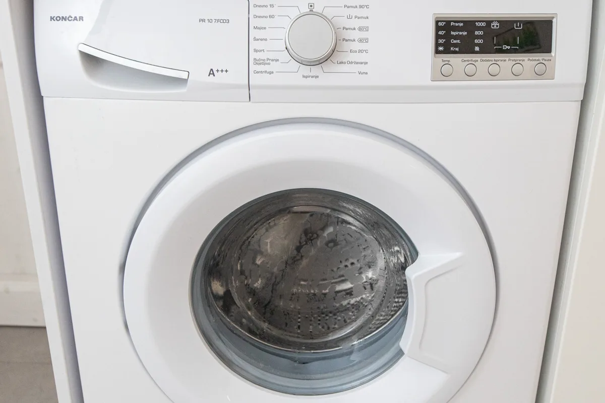 Washing machine built in under the oak kitchen worktop in Woody 2 studio apartment, Zagreb