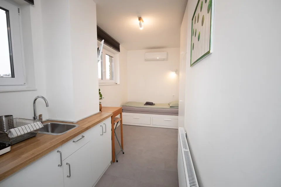 Woody 3 compact studio apartment in Zagreb with a galley kitchenette and alcove bed