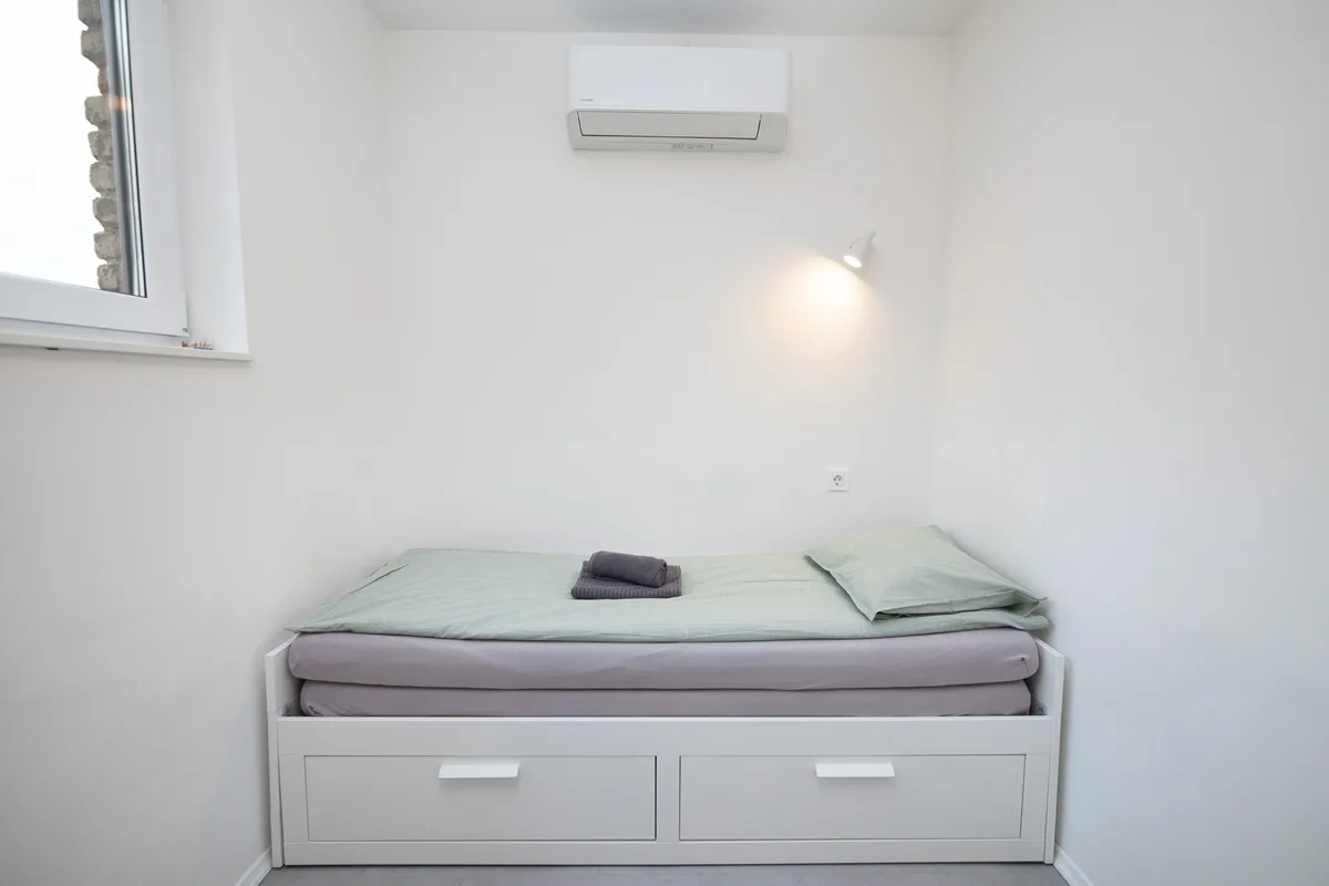 Alcove bed made up as a single with storage drawers beneath in Woody 3 studio apartment, Zagreb