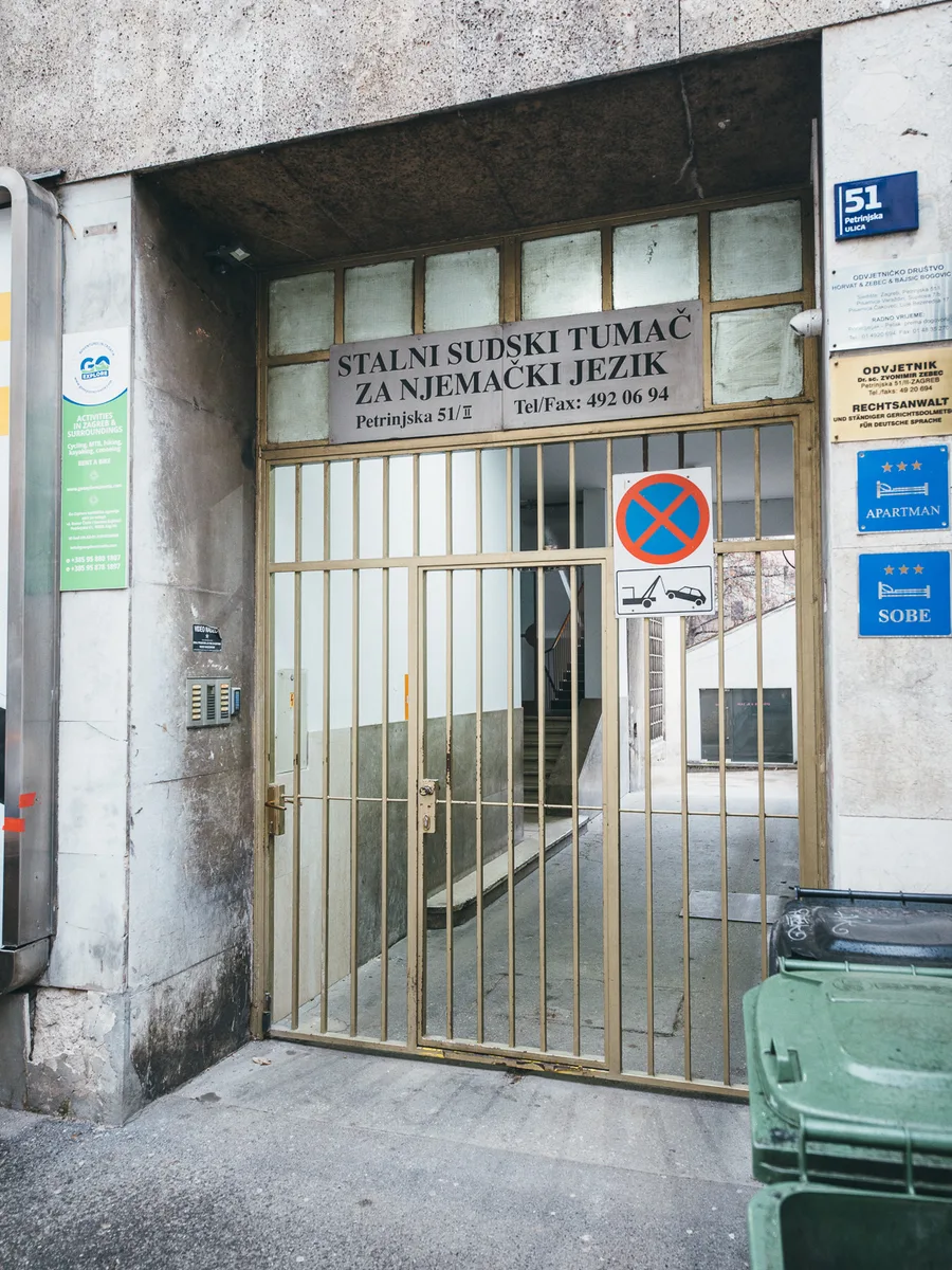 Gated street entrance at Petrinjska 51 in Zagreb with the blue street number plate and category plaques